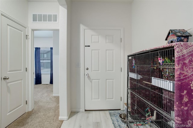 foyer entrance featuring light wood-style floors, baseboards, and visible vents