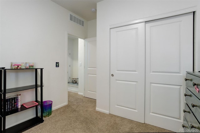 bedroom featuring baseboards, a closet, visible vents, and light colored carpet