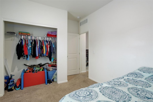 bedroom featuring a closet, carpet flooring, visible vents, and baseboards