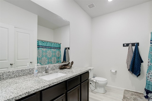 full bath featuring toilet, wood finished floors, vanity, visible vents, and baseboards