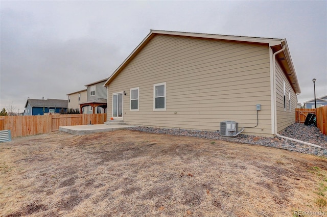 rear view of property with entry steps, a patio area, a fenced backyard, and central air condition unit