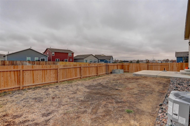 view of yard with a fenced backyard, a patio, and central AC