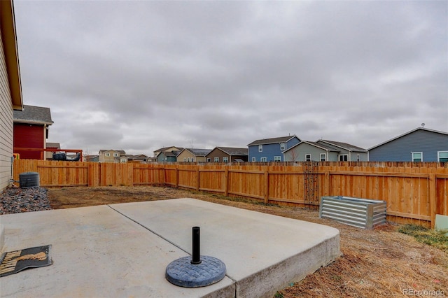 view of patio featuring a fenced backyard, a residential view, and central AC