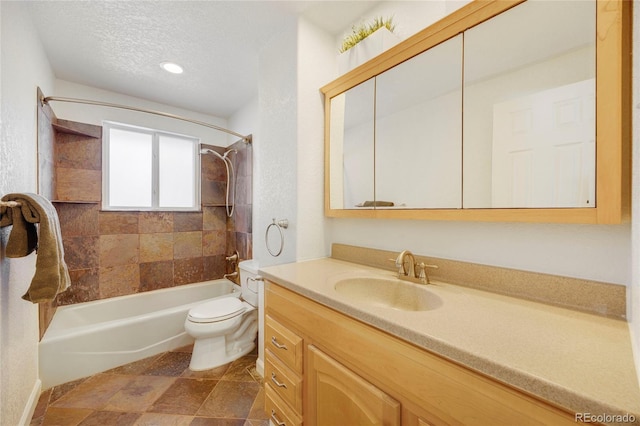 full bathroom featuring vanity, tiled shower / bath, toilet, and a textured ceiling