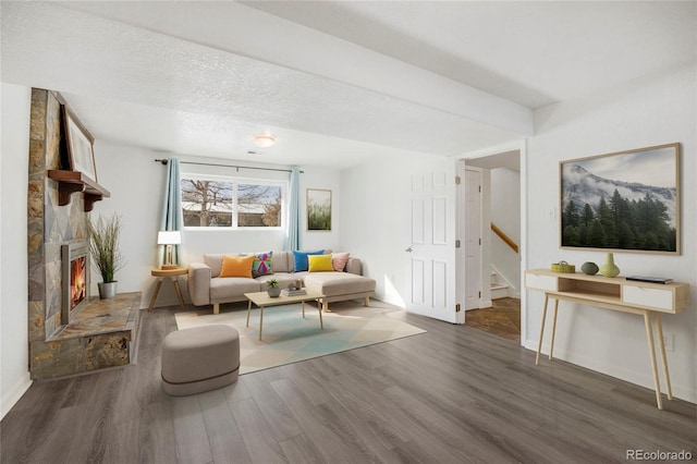 living room featuring a textured ceiling, a fireplace, and dark hardwood / wood-style flooring