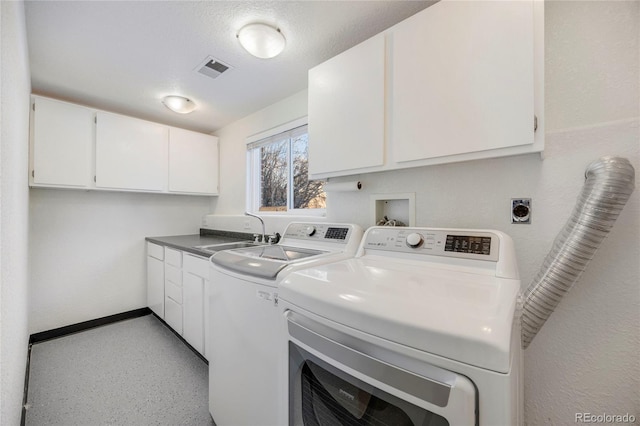 laundry area featuring independent washer and dryer, sink, cabinets, and a textured ceiling