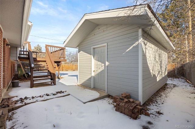 snow covered property with an outbuilding and a deck