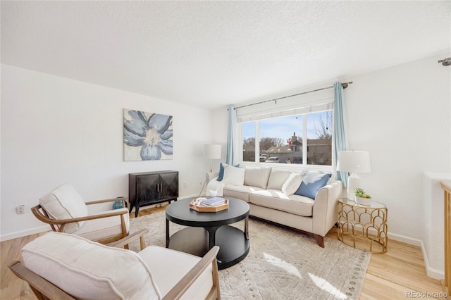 living room with light hardwood / wood-style floors and a textured ceiling