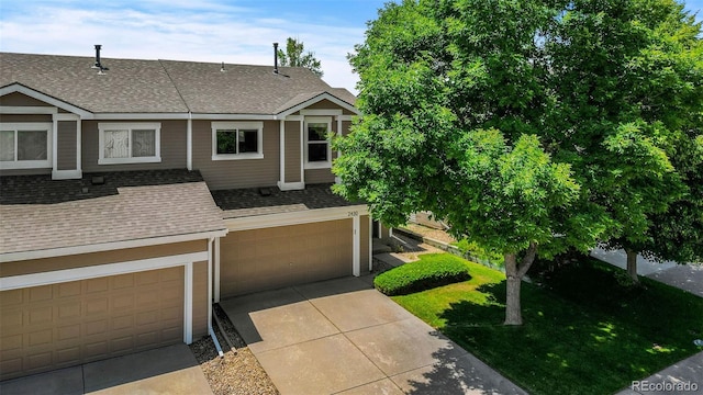 2430 E 109th Dr, Northglenn, CO 80233 - townhome / multi-family property with roof with shingles, an attached garage, a front lawn, and driveway