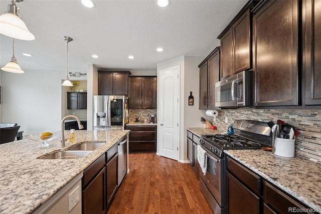 19760 W 59th Dr, Golden, CO 80403 - kitchen featuring appliances with stainless steel finishes, dark wood-type flooring, dark brown cabinetry, pendant lighting, and light stone countertops