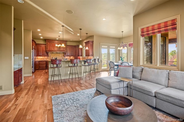 living room featuring a notable chandelier and light hardwood / wood-style floors