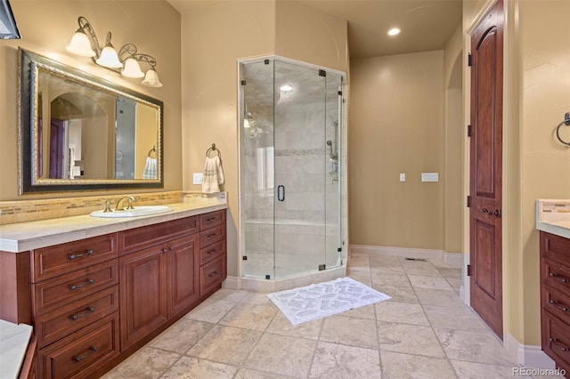 bathroom with a shower with door, vanity, and tile patterned flooring