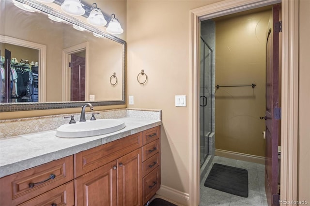 bathroom with a shower with door, tile patterned floors, and vanity