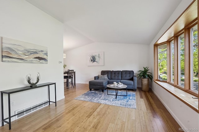 10909 W 65th Way, Arvada, CO 80004 - living area featuring lofted ceiling, hardwood / wood-style flooring, and baseboards