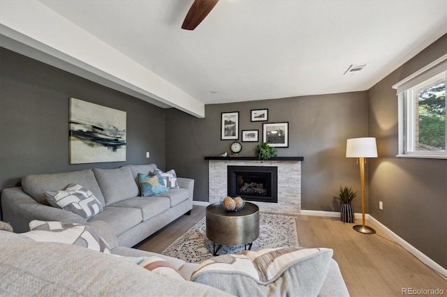 10909 W 65th Way, Arvada, CO 80004 - living room with wood finished floors, baseboards, a ceiling fan, and a fireplace