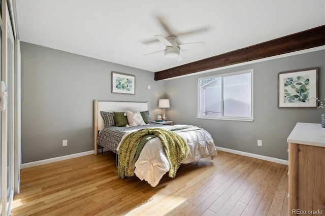 10909 W 65th Way, Arvada, CO 80004 - bedroom featuring baseboards, light wood-style floors, beam ceiling, and ceiling fan