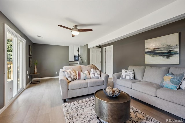 10909 W 65th Way, Arvada, CO 80004 - living room with light wood-style flooring, a ceiling fan, and baseboards