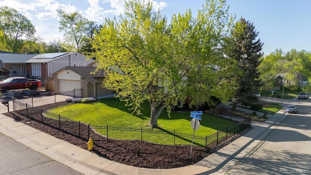 10909 W 65th Way, Arvada, CO 80004 - obstructed view of property featuring brick siding, driveway, and a garage