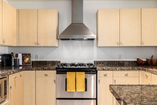 kitchen with light brown cabinetry, wall chimney range hood, and stainless steel appliances