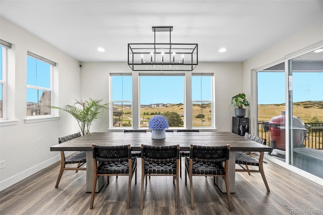 dining room with plenty of natural light, an inviting chandelier, and dark wood-type flooring