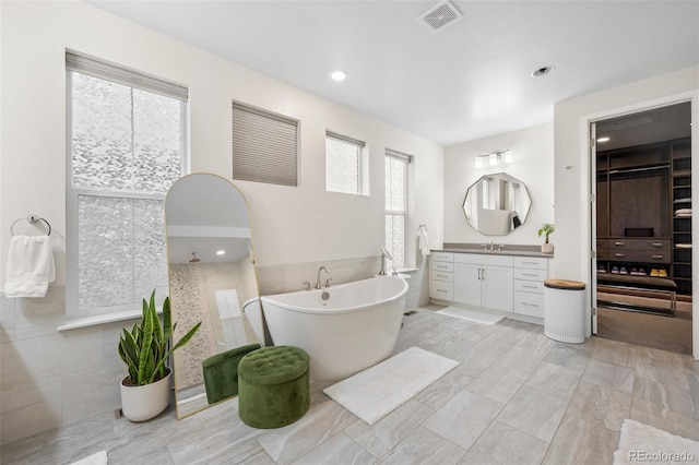 bathroom featuring separate shower and tub, plenty of natural light, and vanity