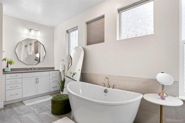 bathroom featuring vanity and a bath