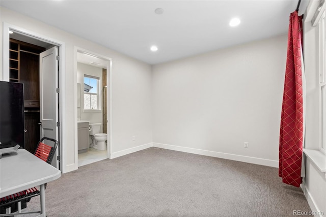 bedroom with light carpet and ensuite bath