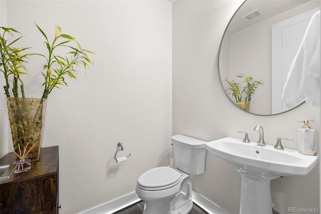 bathroom featuring hardwood / wood-style floors and toilet