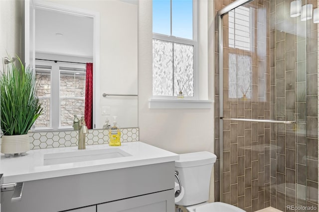 bathroom featuring vanity, toilet, and a shower with shower door