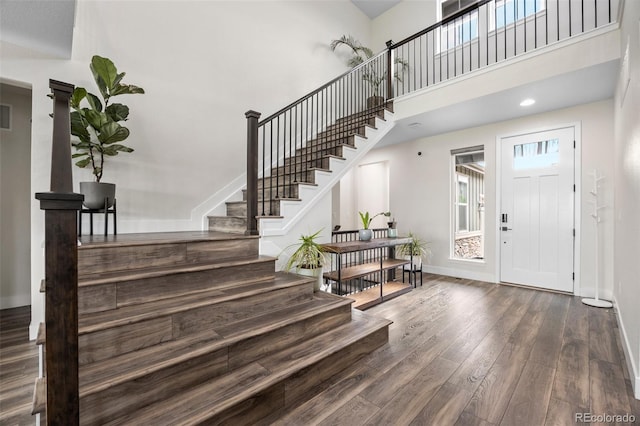 foyer entrance featuring dark wood-type flooring and a high ceiling