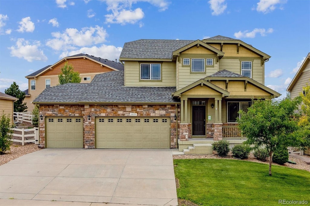 craftsman house with a garage and a front lawn