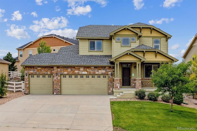 craftsman house with a garage and a front lawn