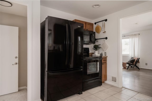 916 Florence St, Aurora, CO 80010 - kitchen featuring black appliances, brown cabinets, and light tile patterned floors