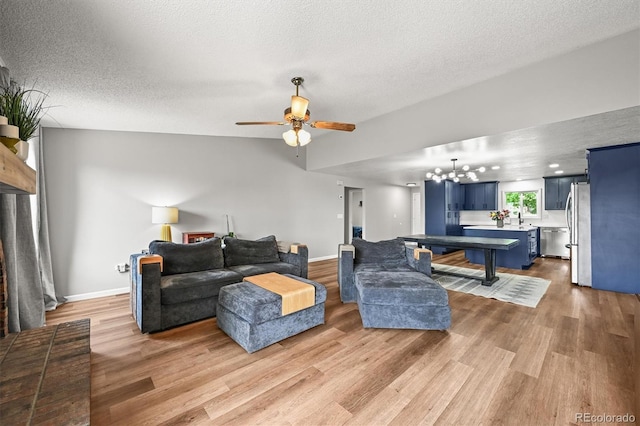 3881 S Bahama St, Aurora, CO 80013 - living area with light wood-style floors, a chandelier, a textured ceiling, ceiling fan, and baseboards