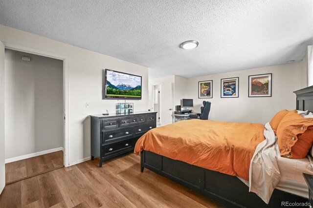 3881 S Bahama St, Aurora, CO 80013 - bedroom with wood finished floors, a textured ceiling, and baseboards