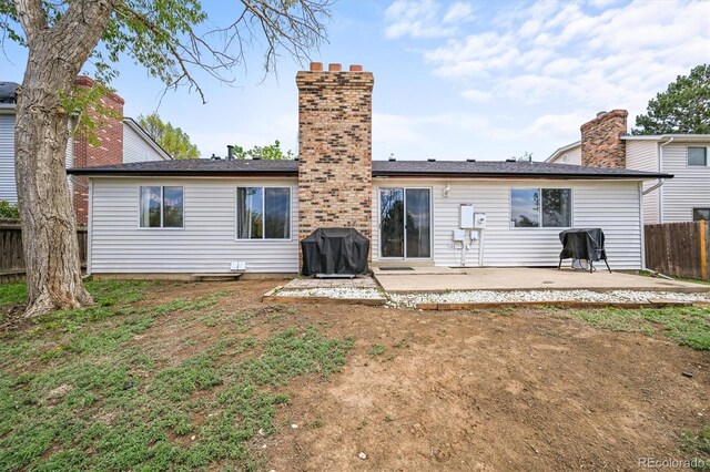 3881 S Bahama St, Aurora, CO 80013 - back of property with a patio, fence, and a chimney