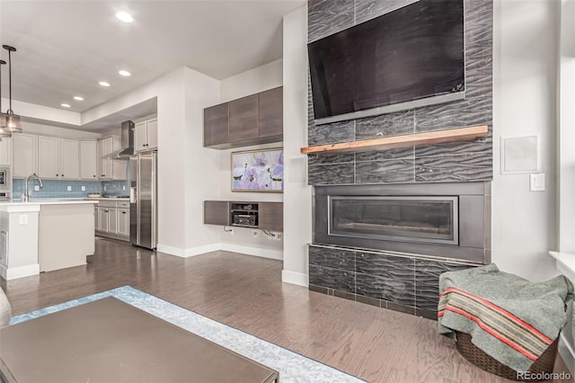 5834 Beeler Ct, Denver, CO 80238 - kitchen featuring dark wood-style flooring, wall chimney range hood, high quality fridge, light countertops, and decorative backsplash