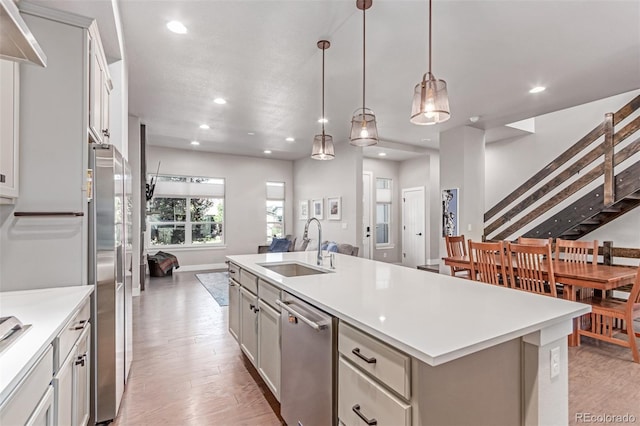 5834 Beeler Ct, Denver, CO 80238 - kitchen with stainless steel appliances, recessed lighting, open floor plan, light countertops, and a center island with sink