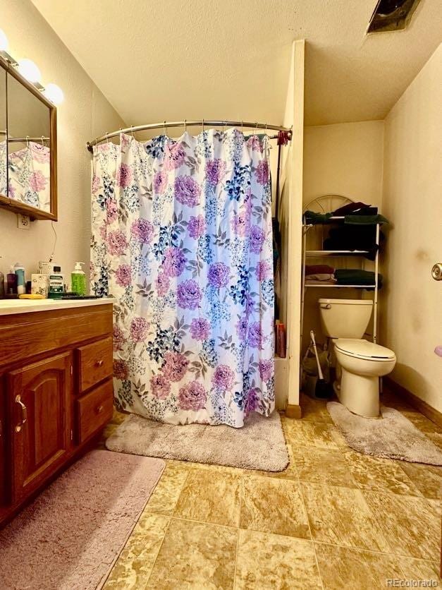 bathroom featuring oversized vanity, toilet, tile flooring, and a textured ceiling