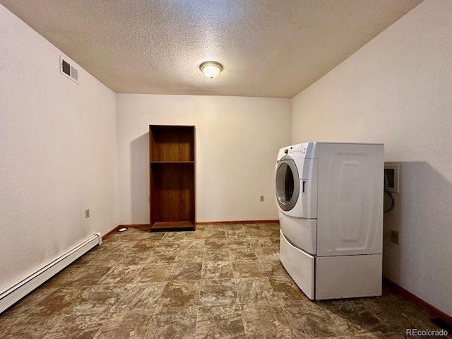 laundry room featuring baseboard heating, washer / dryer, tile floors, and a textured ceiling