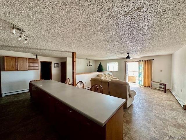 kitchen featuring ceiling fan, baseboard heating, and a textured ceiling