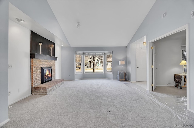 unfurnished living room featuring light carpet, high vaulted ceiling, a brick fireplace, and baseboards