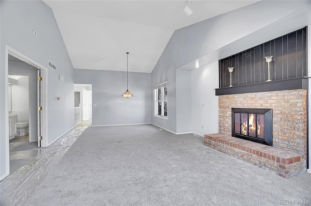 unfurnished living room featuring high vaulted ceiling, a brick fireplace, carpet flooring, and baseboards