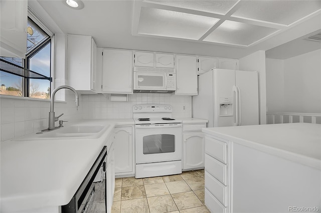 kitchen featuring white appliances, a sink, white cabinets, light countertops, and tasteful backsplash