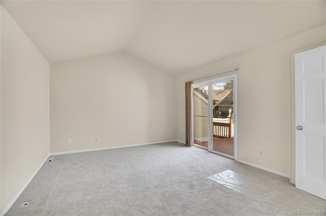 interior space featuring lofted ceiling, light carpet, and baseboards