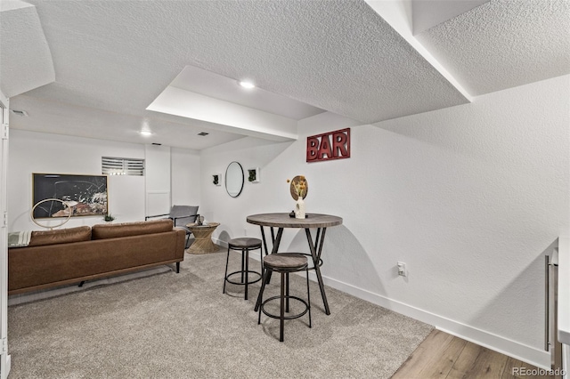 interior space featuring a textured ceiling, light wood finished floors, visible vents, and baseboards