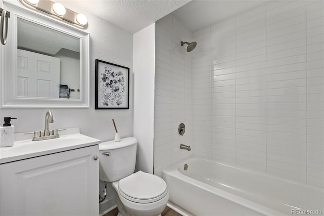 full bathroom with bathing tub / shower combination, a textured wall, toilet, vanity, and a textured ceiling