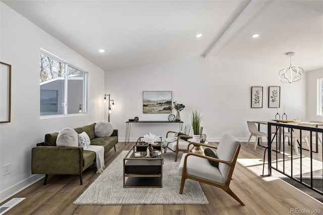 living room with vaulted ceiling with beams, hardwood / wood-style floors, and a chandelier