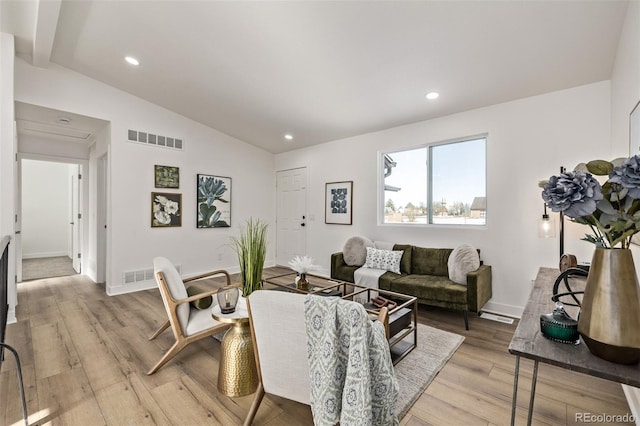 living area with recessed lighting, visible vents, vaulted ceiling, and light wood-style flooring