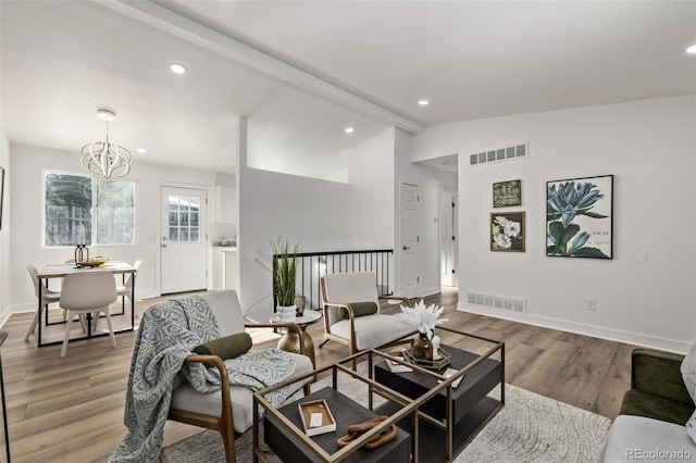 living room featuring vaulted ceiling with beams, wood finished floors, visible vents, and recessed lighting